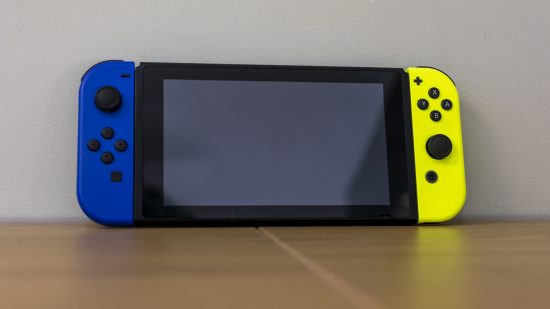 Nintendo Switch console in front of a gray wall on a desk